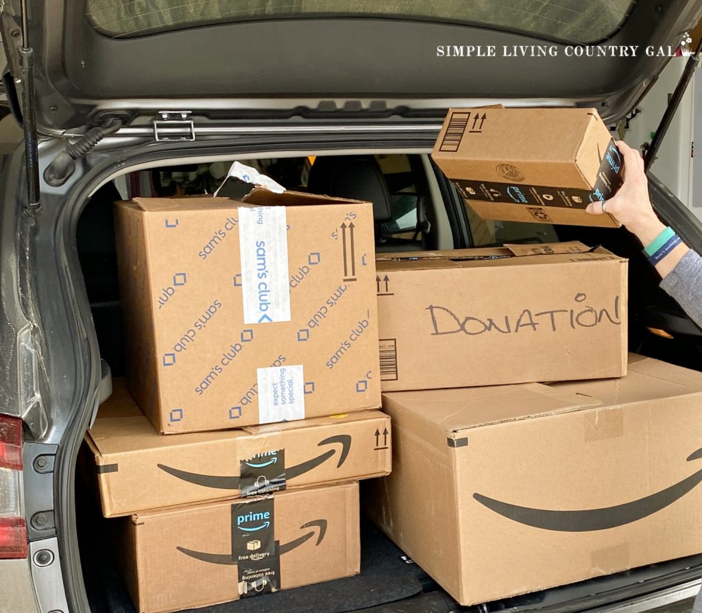 woman putting donation boxes in the back of her car