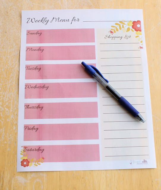 A pink weekly menu printable with a blue pen on top