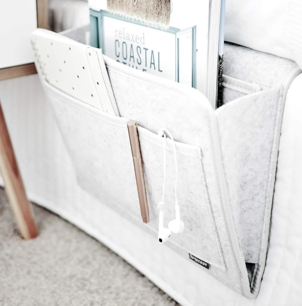 Bed caddy filled with books on a bed