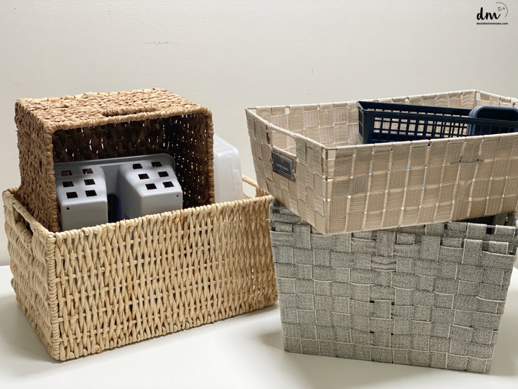 a collection of baskets and bins stacked on a white table