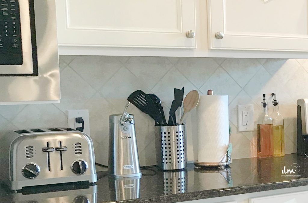 a counter in a kitchen lined with small gadgets and jars.
