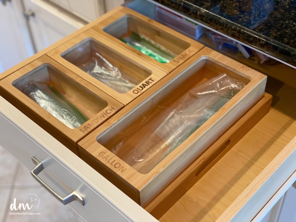 a wooden bin in a drawer used to organize plastic bags