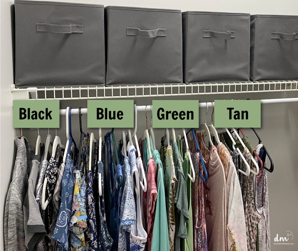 clothes in hanging in a closet with green boxes naming each color above