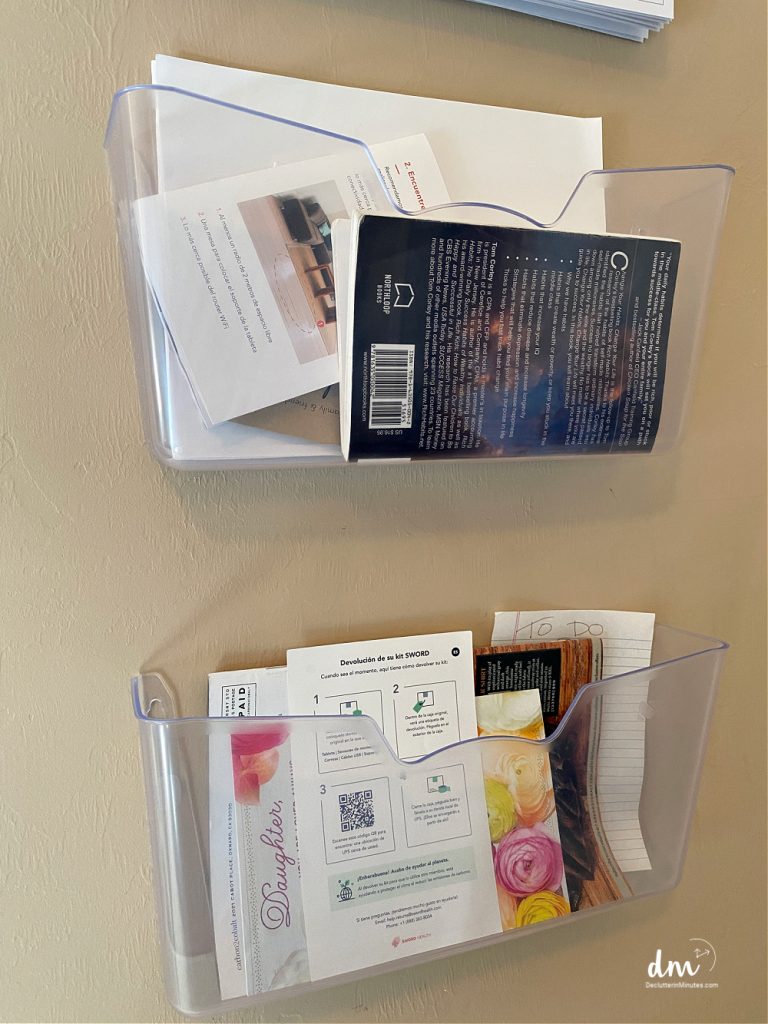 2 plastic file bins on a wall full of paper clutter and books