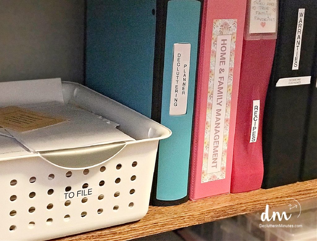 a basket labeled to be filed next to binders in a home office