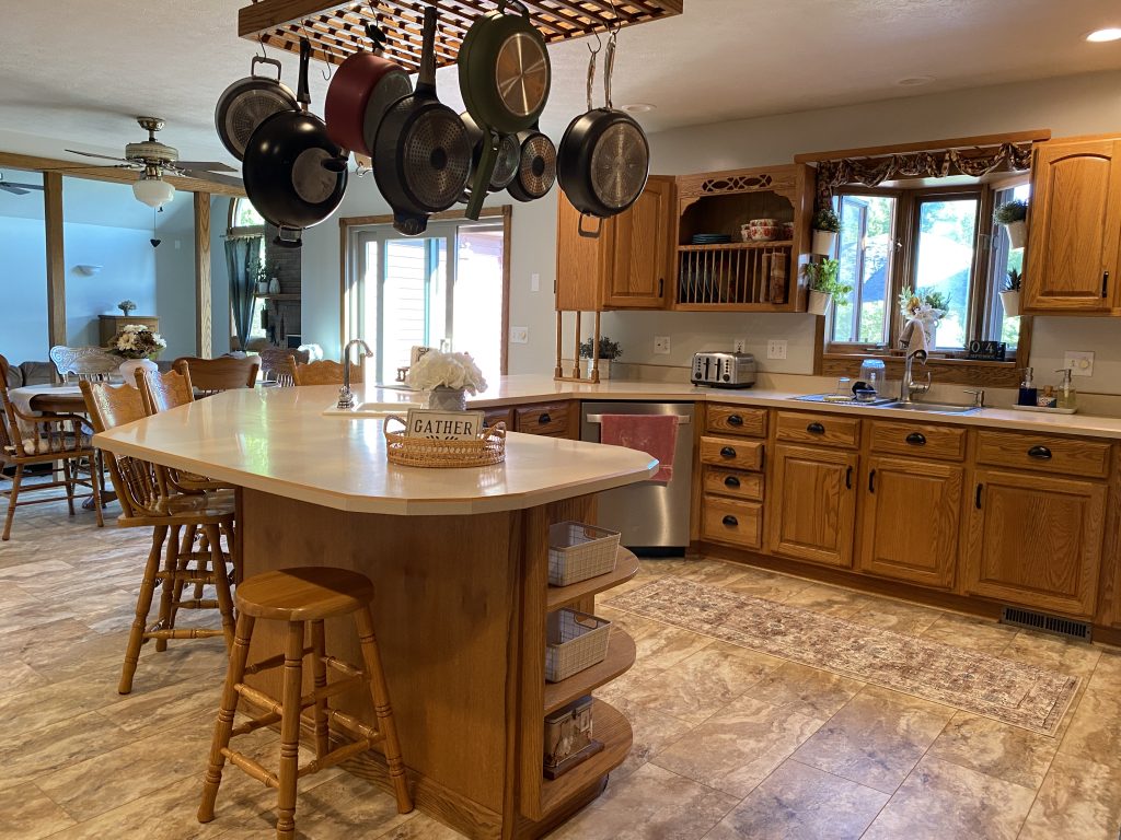 Clean Kitchen countertop with pots and pans hanging on the ceiling rack.
