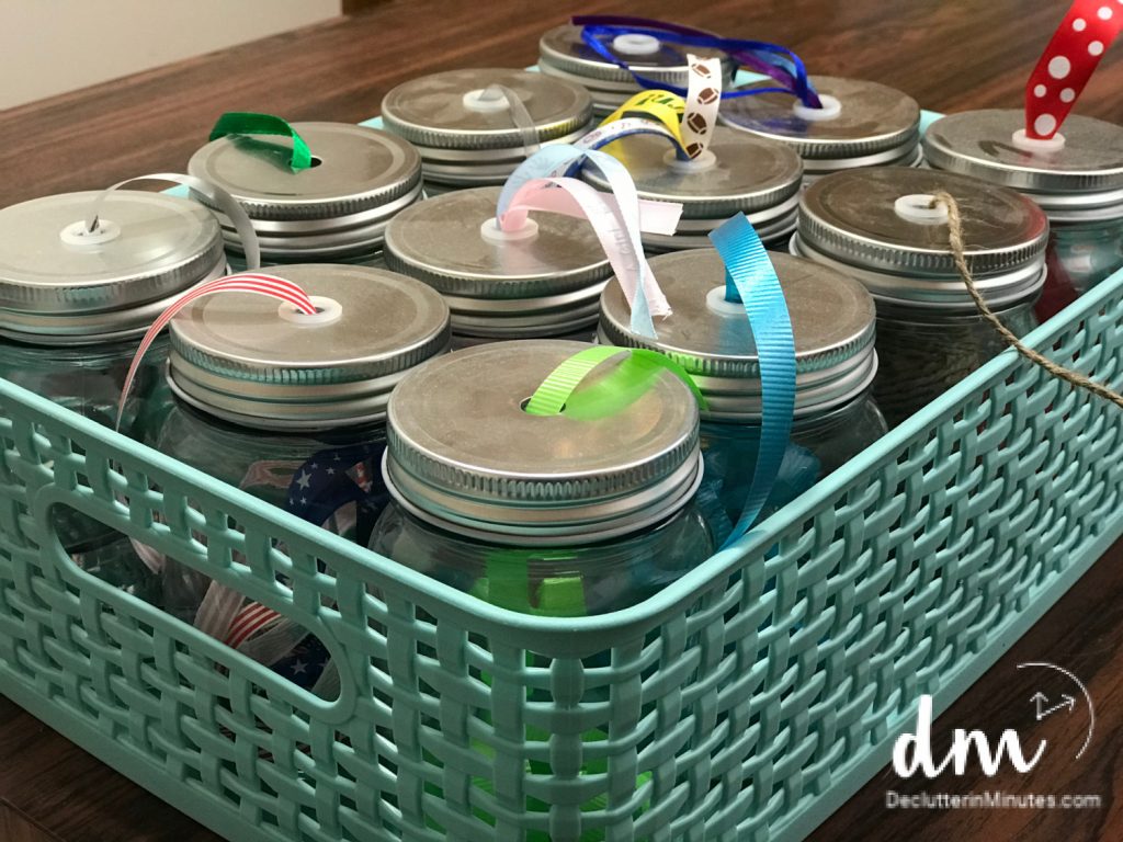 a set of mason jars full of ribbons for craft projects