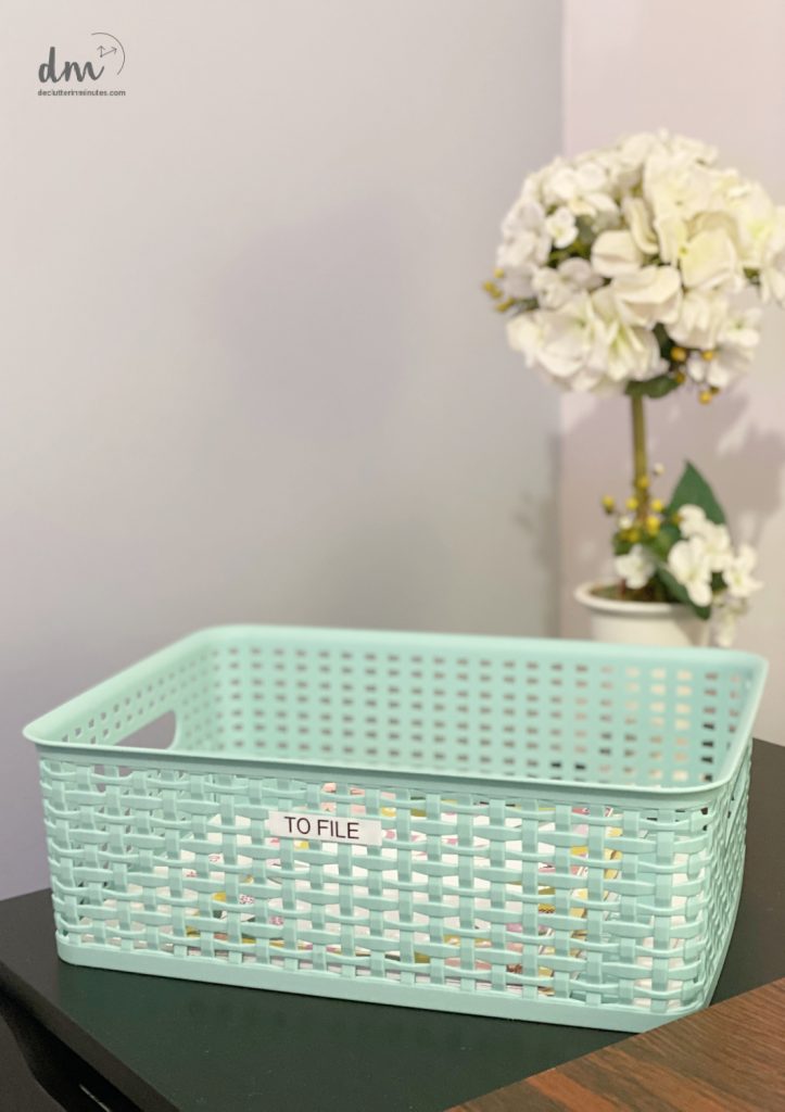 A mint green basket labeled "TO FILE," sitting on a desk