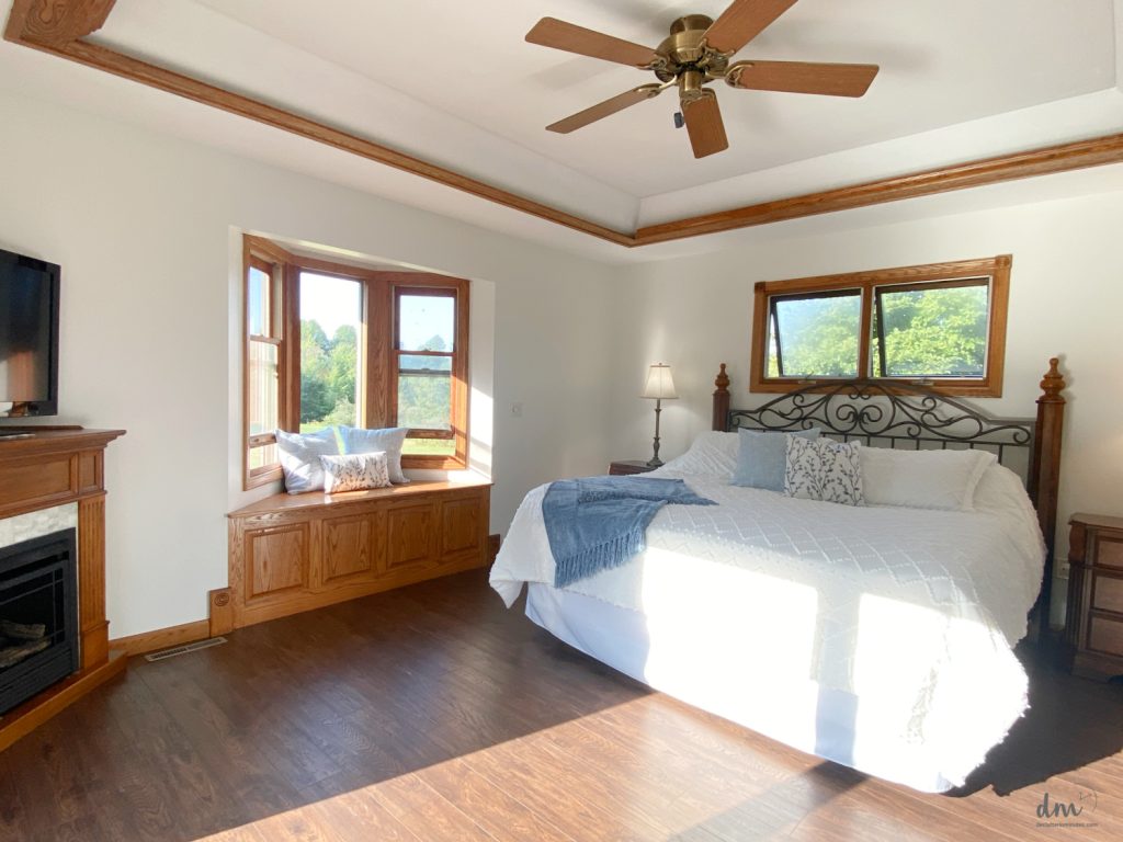 a white bed in a bedroom that is open and clutter-free