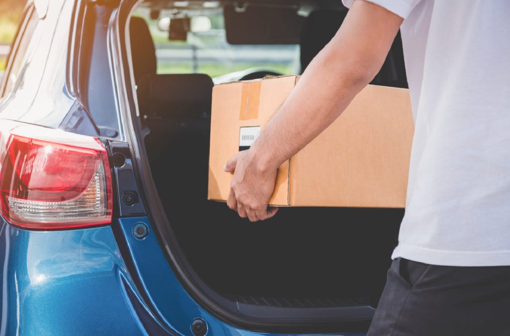 man putting a donation box in the trunk of his car