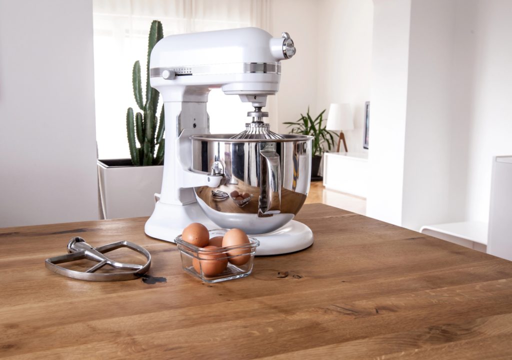 a white mixer on a wood counter in a kitchen