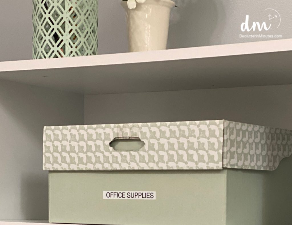 a small cardboard box labeled office supplies on a shelf in a command center