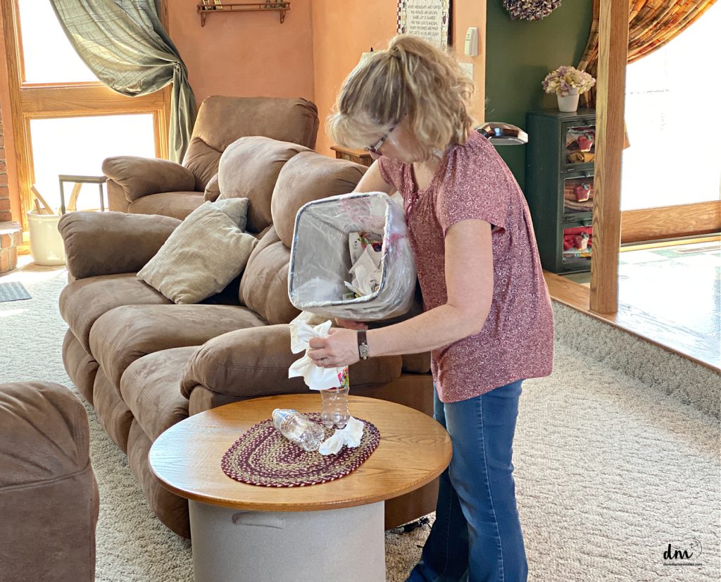 a woman picking up trash in a family room