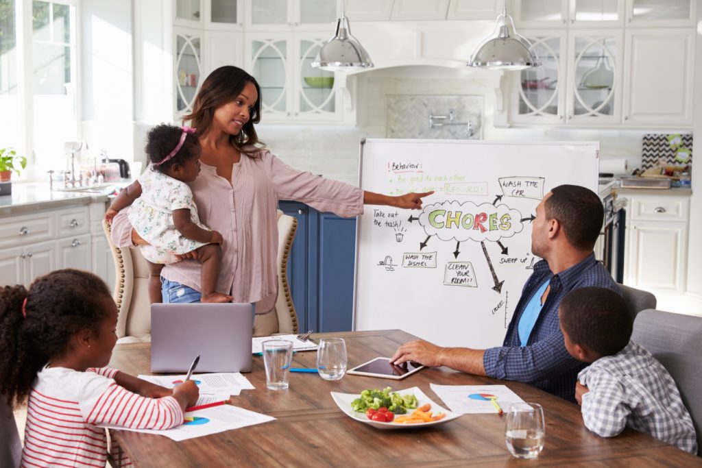 family meeting at a kitchen table talking about family chores