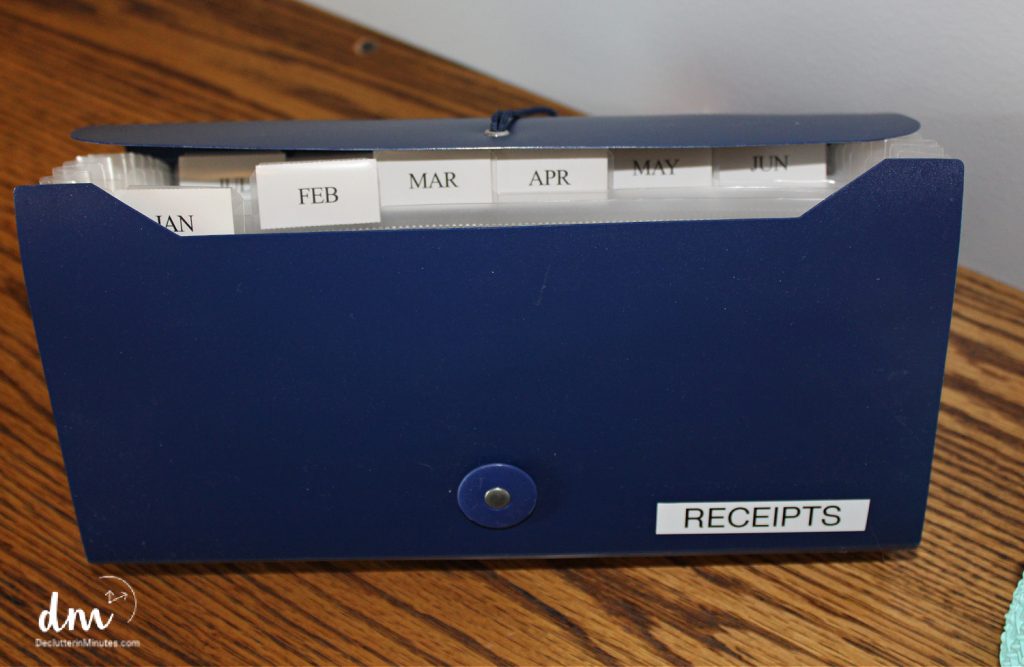 A navy blue accordion file labeled "RECEIPTS," with monthly tabs for sorting and storing financial records