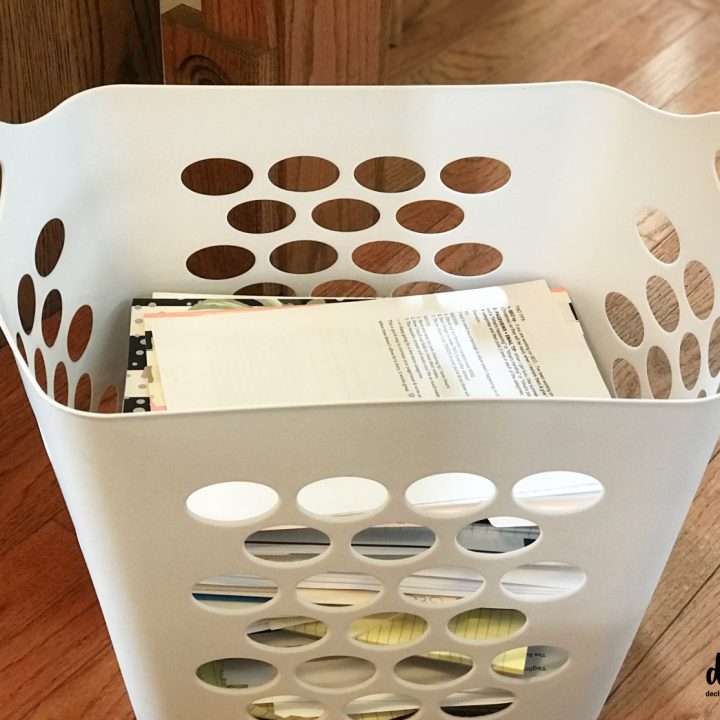 a white laundry basket full of paper clutter waiting to be sorted