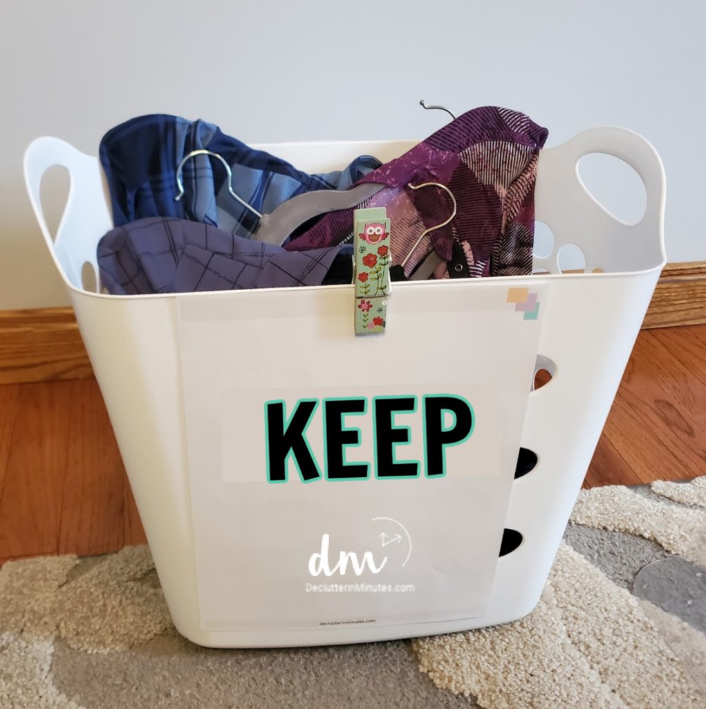 a white laundry basket with a sign that says keep on the front filled with clothes