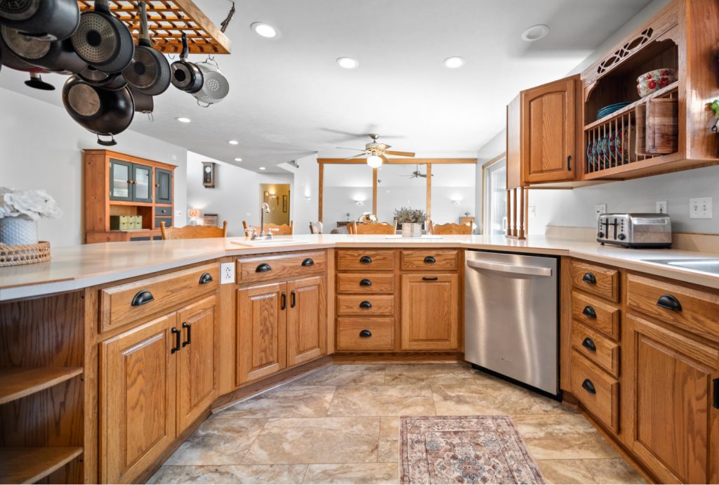 a brown kitchen with clutter free counters and a pot rack