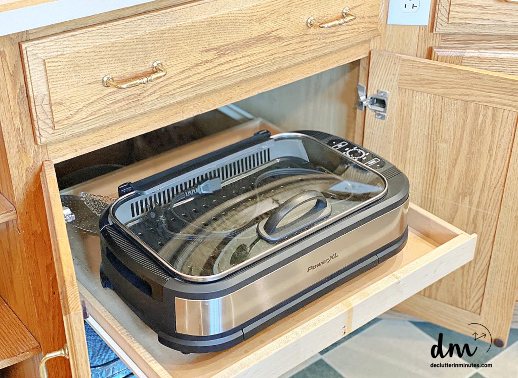 An indoor grill stored in a pull-out cabinet drawer 
