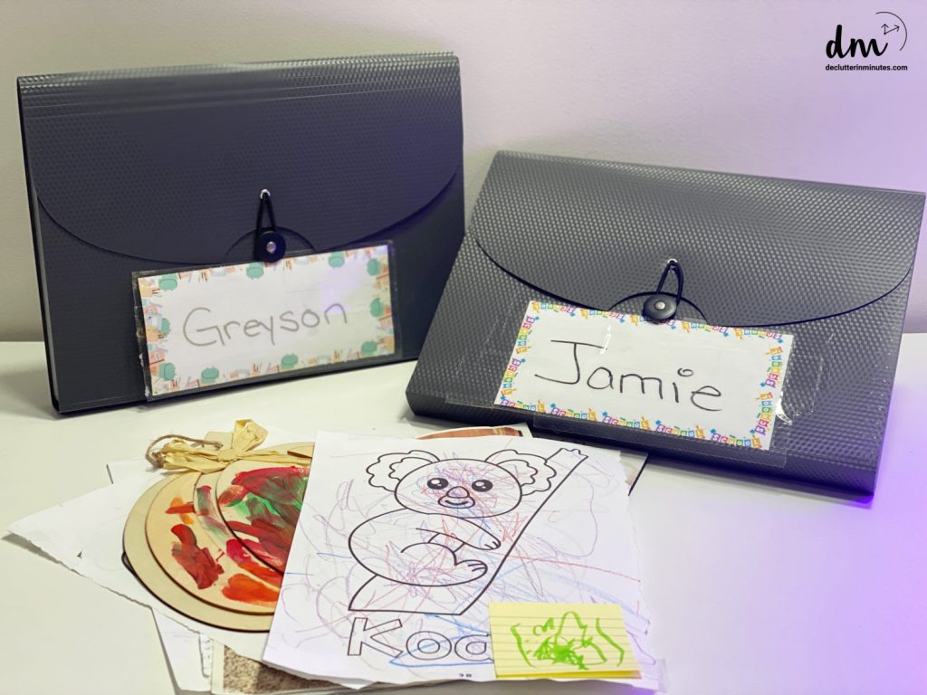 expanding files labeled Jamie and Greyson with a pile of artwork in the front