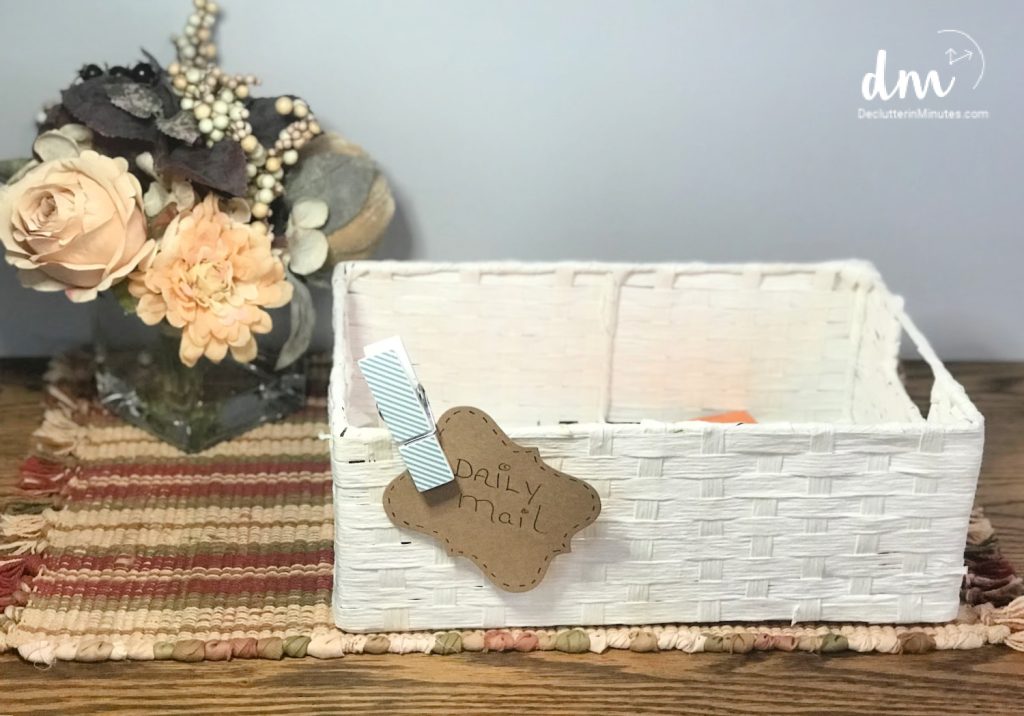 a white basket labeled "daily mail" sitting on a counter next to flowers