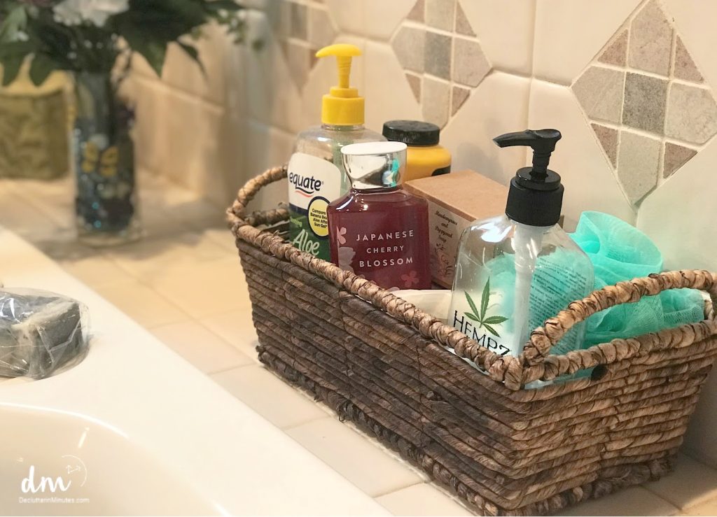 Image that shows a wicker basket over the tub that holds lotion, Aloe and soap. 