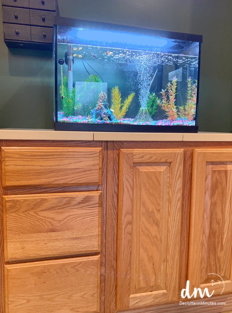 a fish tank on a cabinet used for storing fish supplies
