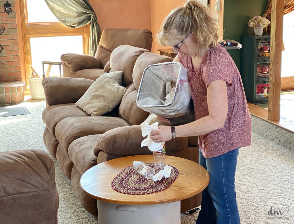 a woman cleaning up trash in a family room 