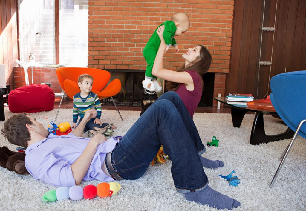 a young family playing together in a family room 