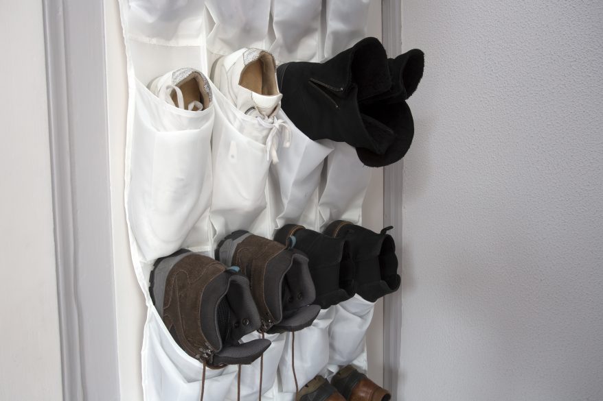 Image that shows a cloth shoe sorter hung on a closet door.