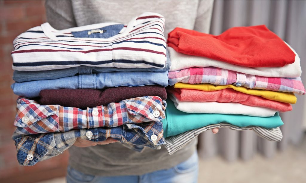 Woman holding piles of clothes, closeup