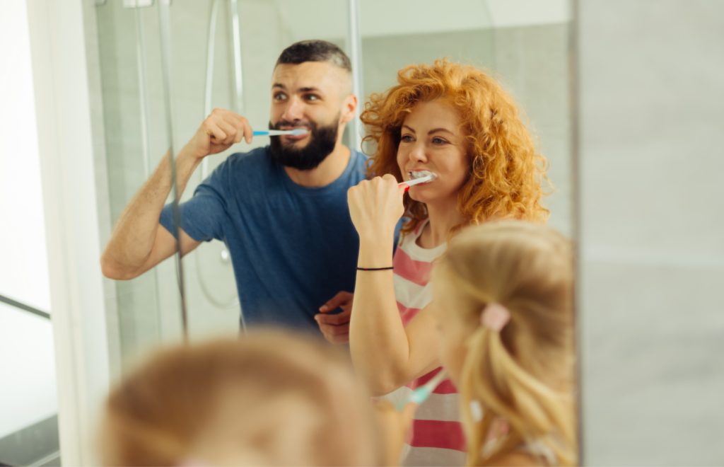 a family brushing their teeth in a bathroom
