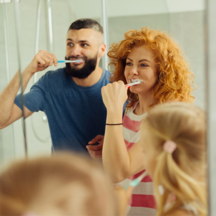 a family brushing their teeth in a bathroom