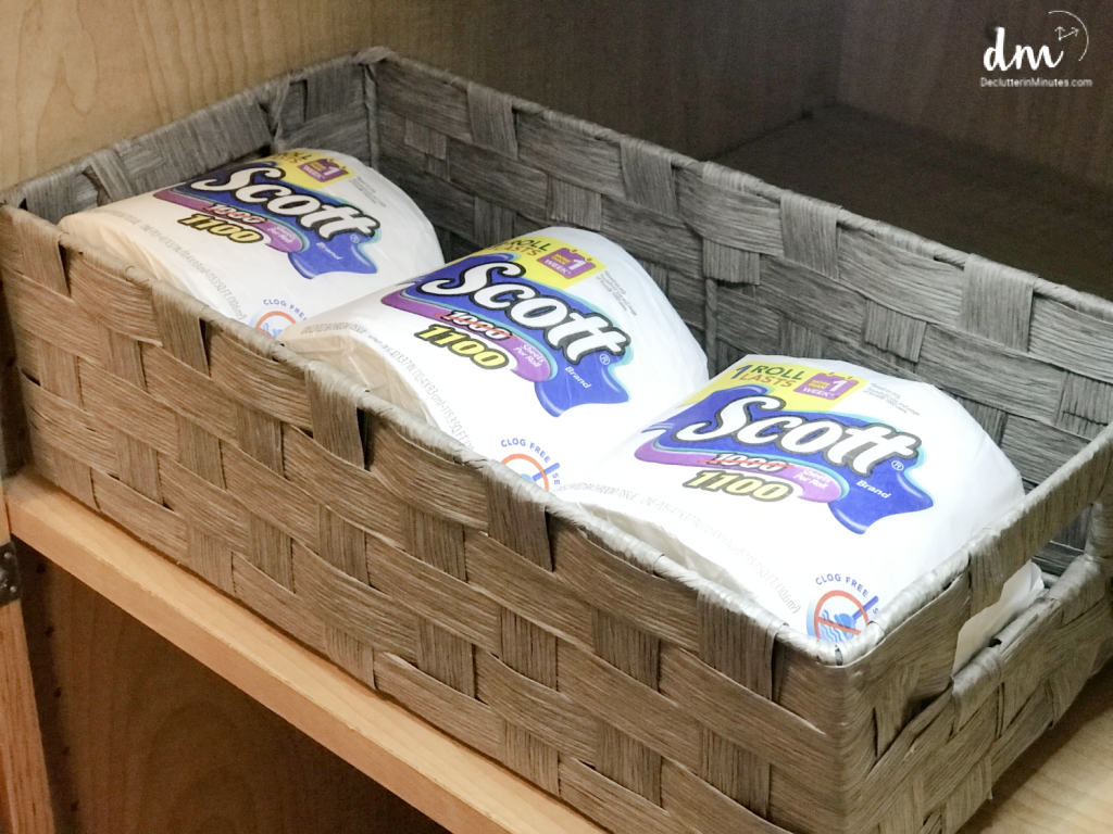 a gray basket filled with toilet paper rolls