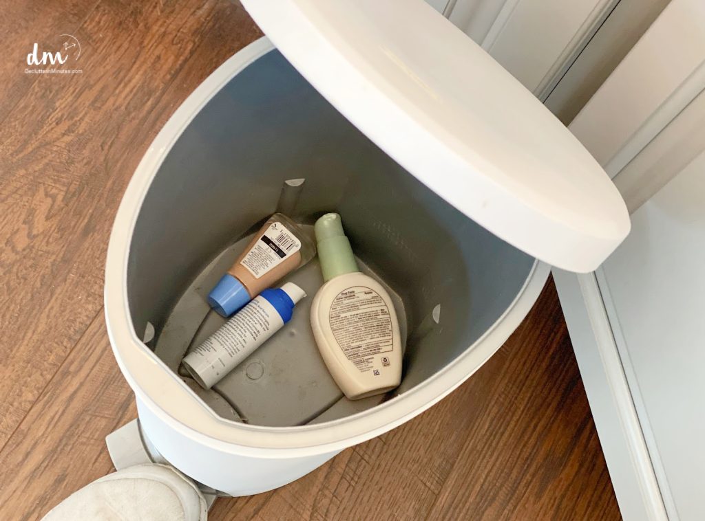 a white trash can with makeup and lotion inside