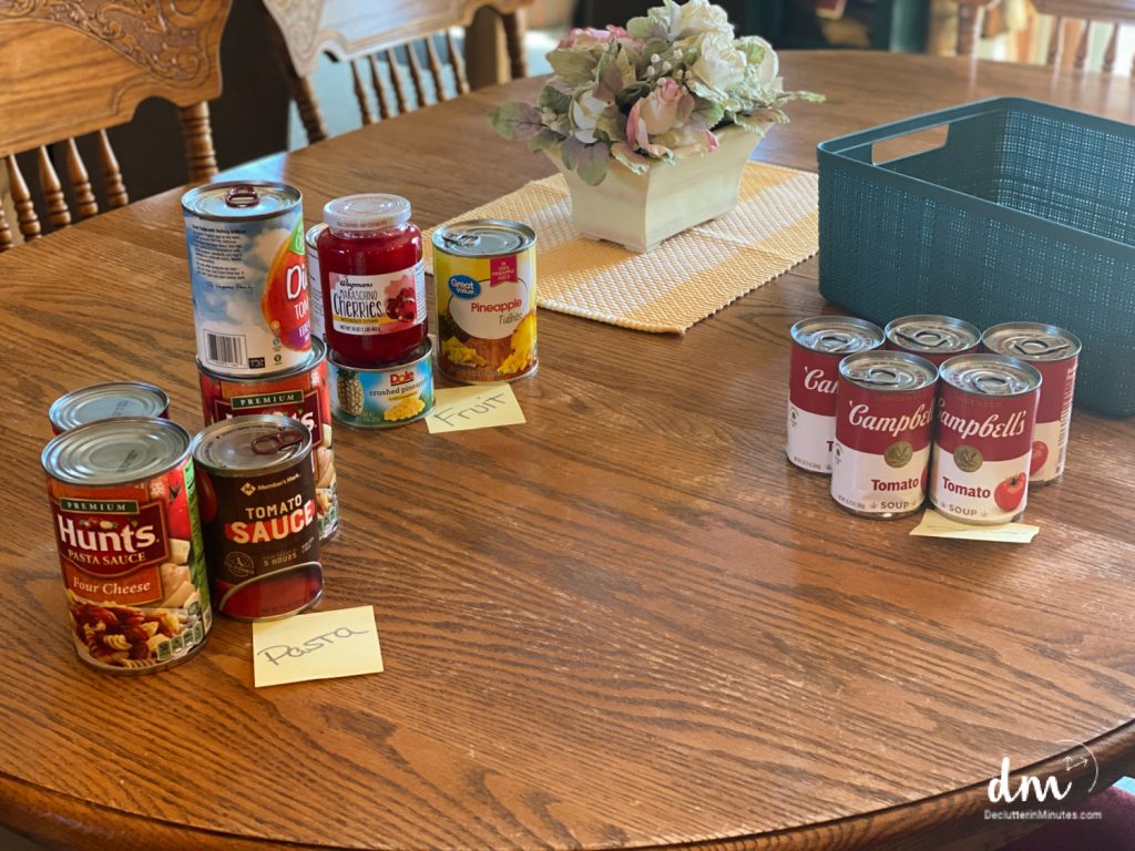 canned goods sorted into categories on a kitchen table