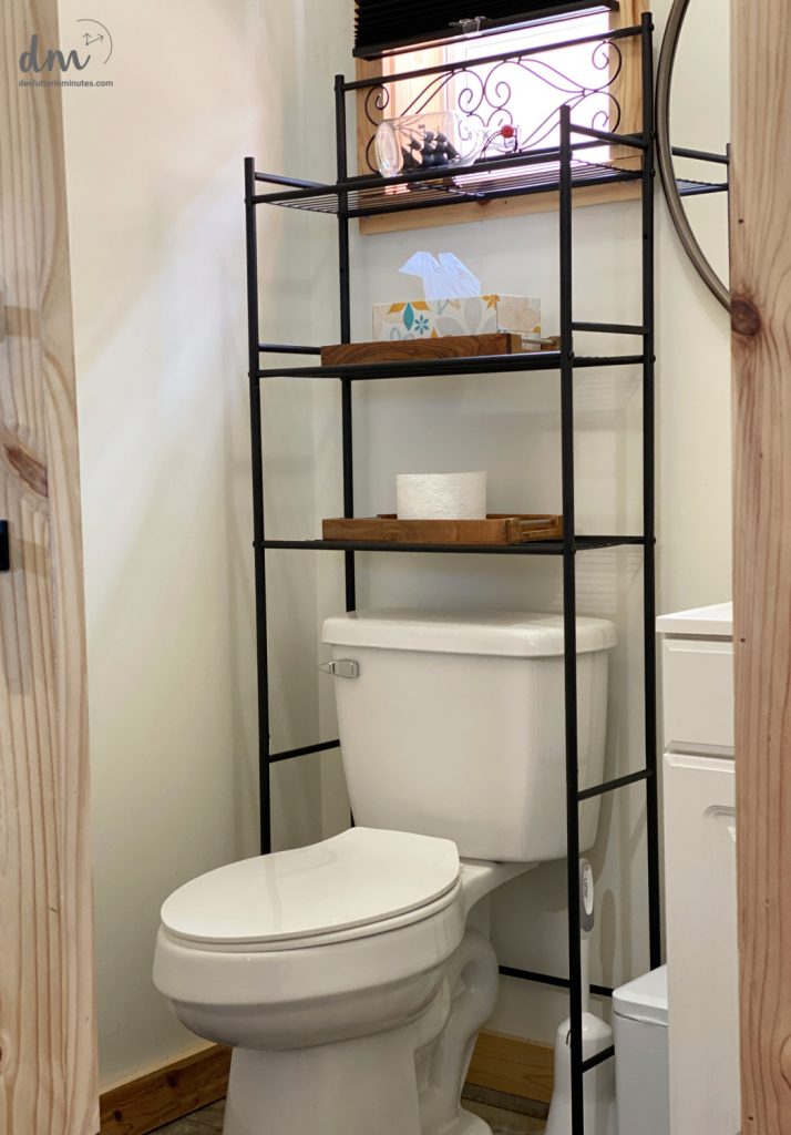 storage shelves over a toilet in an organized bathroom 