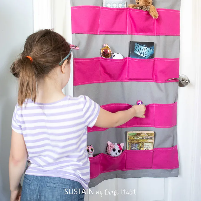 An image that shows a DIY over the door shoe storage that holds books, and toys in each pocket. 