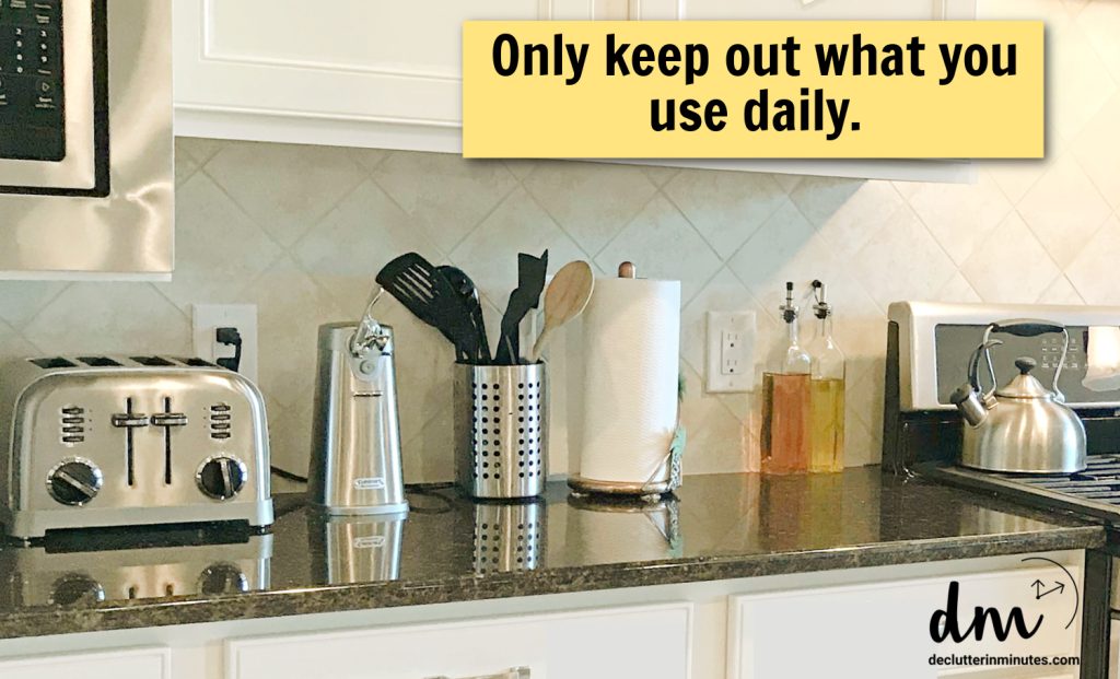 a counter in a kitchen lined with small gadgets-words _only keep out what you use daily_