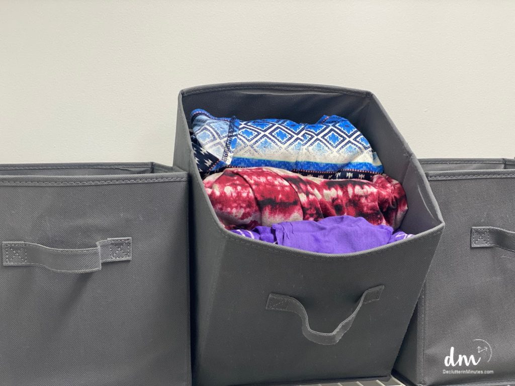 a tipped over storage cube showing clothes inside copy