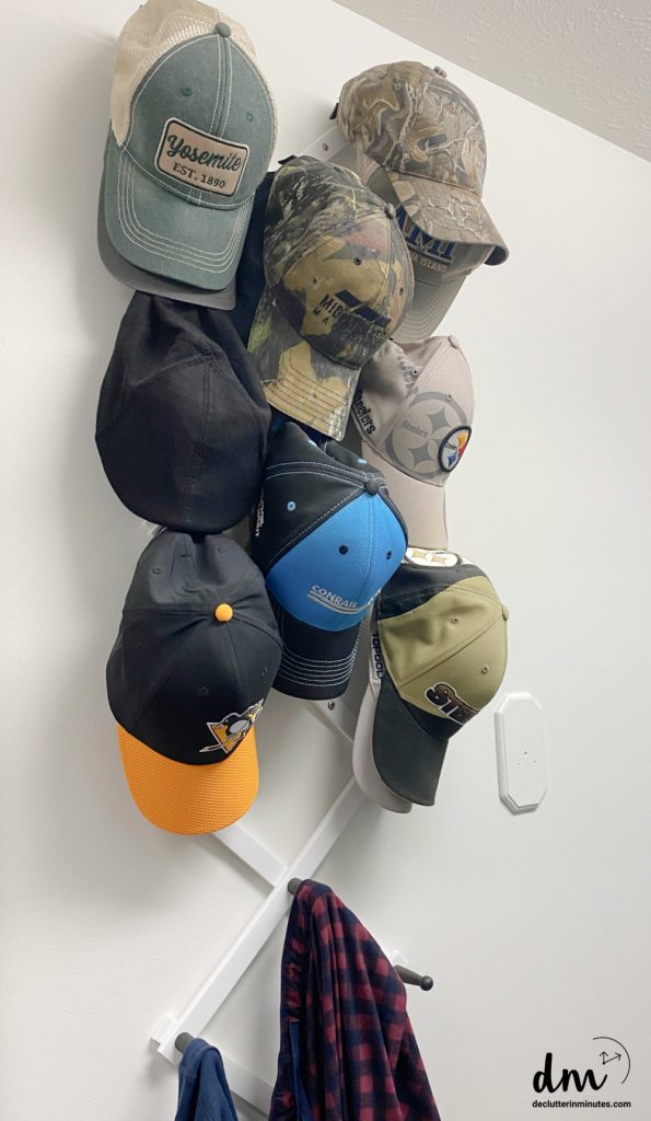 an accordion organizer holding a hat collection on a closet wall