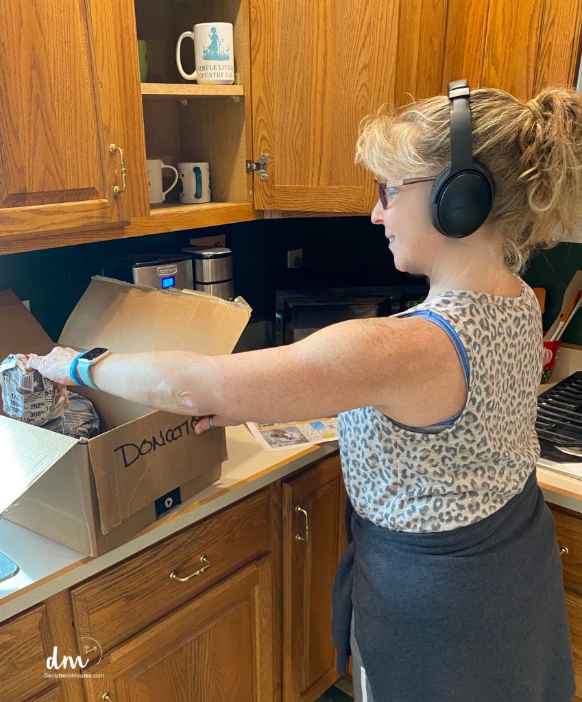 woman cleaning a kitchen with headphones on