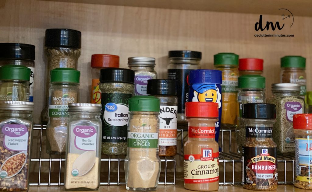 Spices on a wire riser shelf organizer in a cabinet