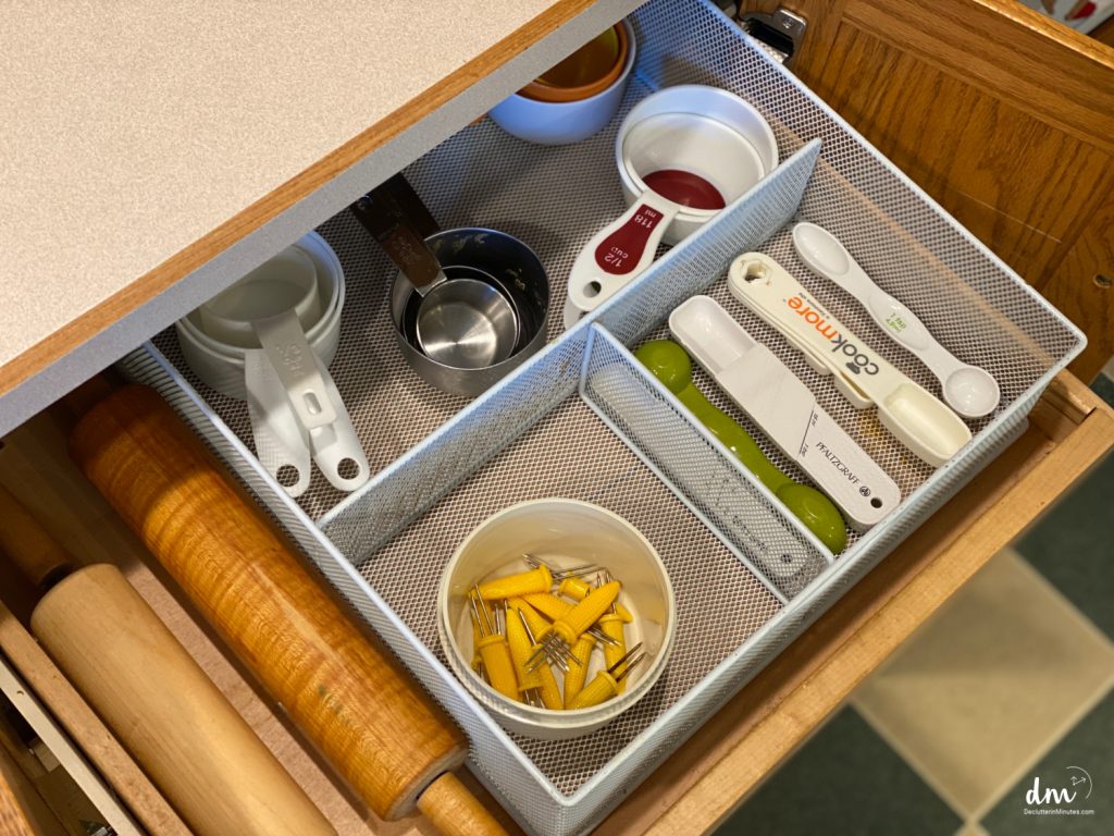 a wire basket in a kitchen holding measuring spoons