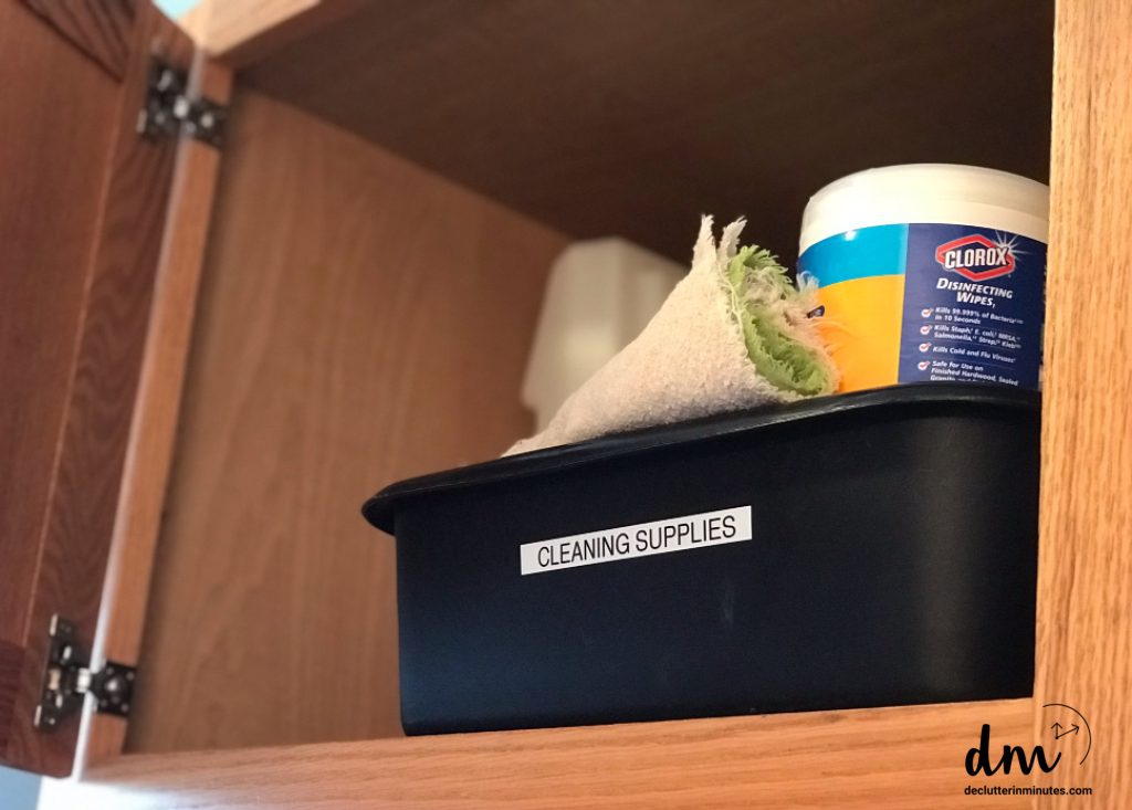 black washtub full of cleaning supplies in a bathroom