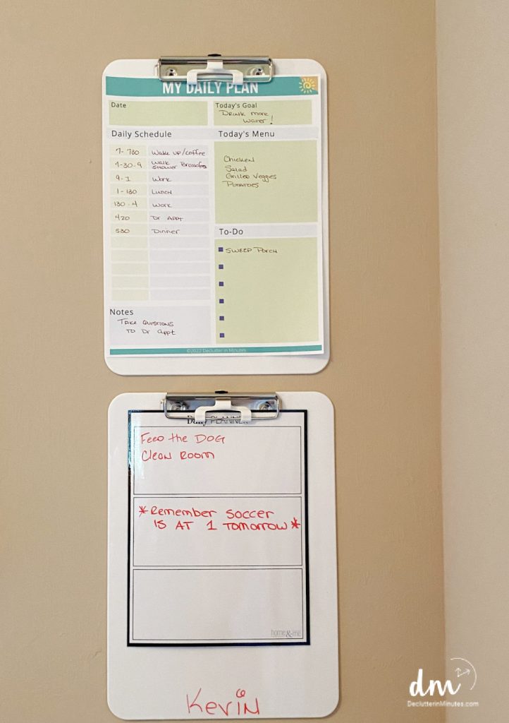 two clipboards on a wall with planner pages on them