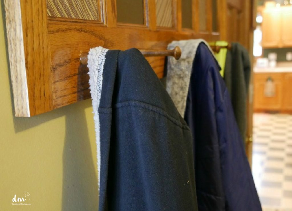 coats hanging on pegs in a mudroom