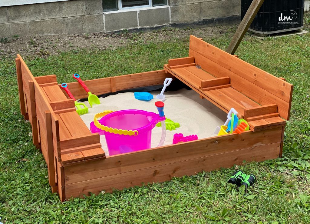sandbox in a backyard with toys inside 