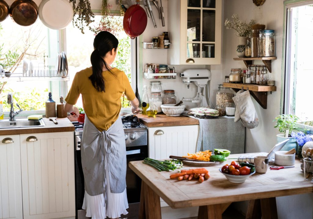 the back of a woman cooking in a small kitchen