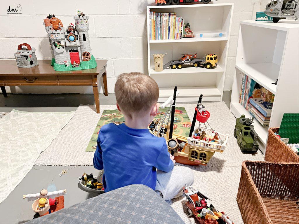 a boy playing with toys in a play room